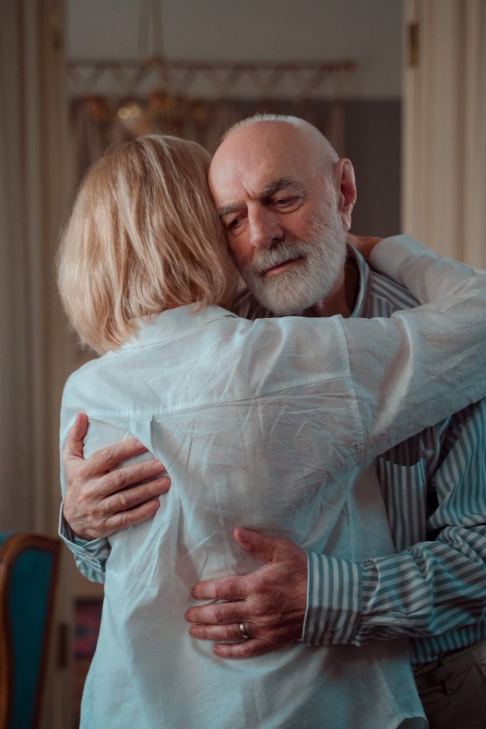 Older couple hugging after a heartfelt conversation about healing.